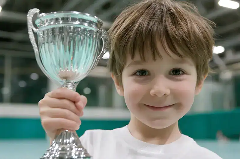 A boy proudly shows his trophy